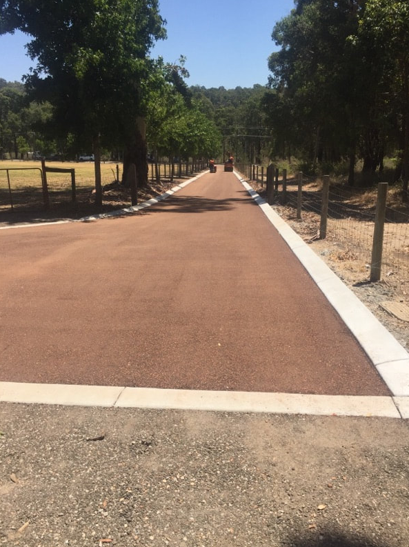 This is a photo of a hot spray & seal bitumen roadway which is in the process of being installed by Shepparton Surfacing Solutions